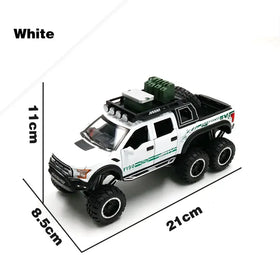 White die-cast ford f-150 pickup truck model with green and black detailing, oversized tires, roof rack, and spare tire.