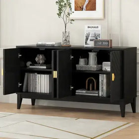 Black modern sideboard with gold-toned handles and geometrically patterned doors, displaying books, decorative items, and a small clock on its surface