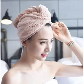 A soft, pink microfiber towel wrapped snugly around a woman’s head.