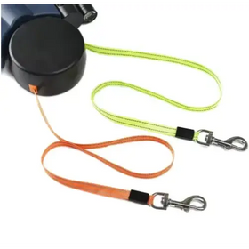 Black retractable dog leash with lime green and orange woven straps, each featuring a black grip section and silver metal clasp.