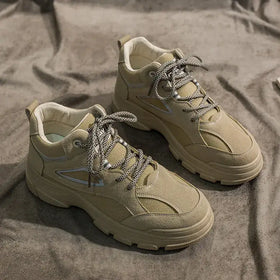 Beige suede and canvas high-top sneakers with chunky soles and silver triangular accents.