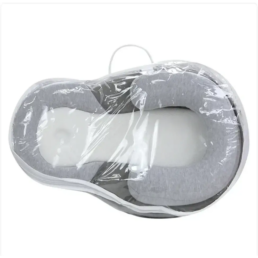 Gray and white memory foam baby sleep positioner wrapped in clear plastic.