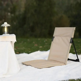 Beige fabric folding chair with black metal frame and adjustable back support.