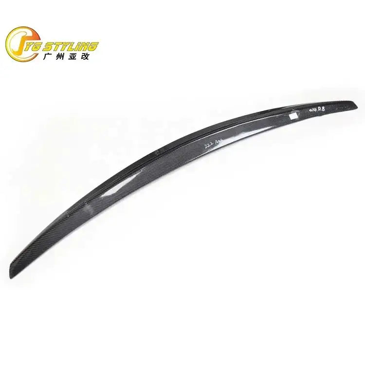 Black carbon fiber rear trunk lid spoiler with a sleek, curved design and subtle glossy finish.