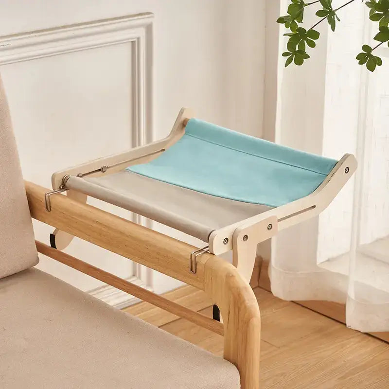 Light wood frame cat bed with a two-tone fabric top in beige and light blue