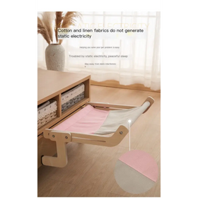 A light pink and gray fabric pet bed with a wooden frame, designed for hanging from furniture.