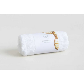 A plush white cotton face towel, neatly rolled and wrapped with a minimalist label featuring gold-toned leaf accents.