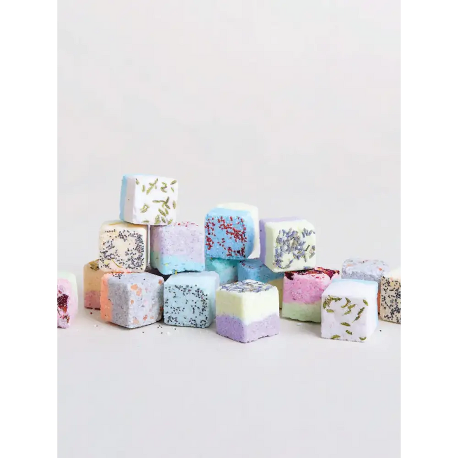 Colorful, cube-shaped bath bombs with lavender and speckled designs.