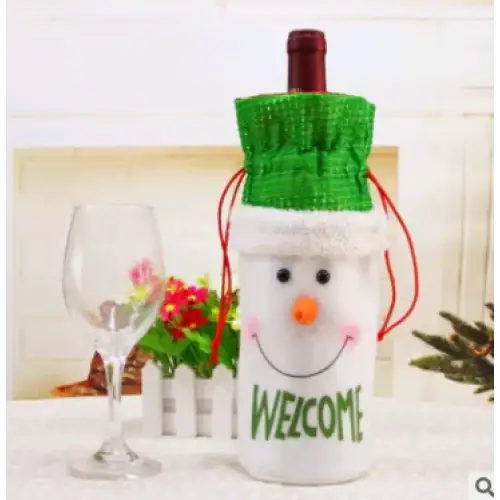 White snowman-themed wine bottle cover with green knitted hat, orange nose, and ’welcome’ text in green lettering.