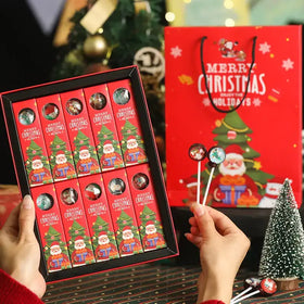 Red christmas-themed gift box containing twelve individually wrapped lollipops with festive santa and tree designs.
