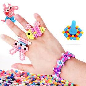 Colorful plastic bead crafts shaped like a pig, butterfly, and rabbit adorn fingers and wrist.