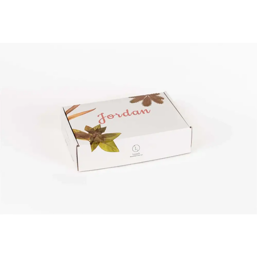 White rectangular box with ’jordan’ printed in pink cursive and illustrated brown and green leaves, featuring a small circular logo for léon’s.