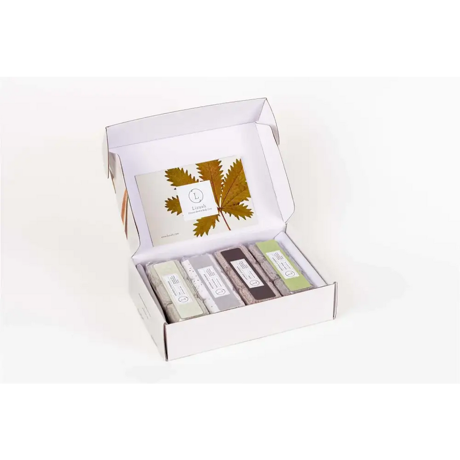White cardboard gift box containing five rectangular soap bars in assorted neutral tones with minimalist labels.