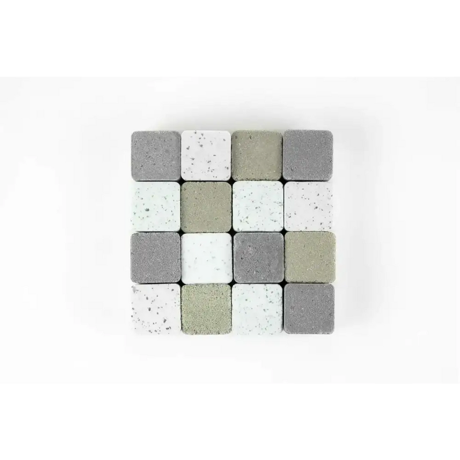 A collection of square concrete pavers in varying shades of gray, white, and beige with speckled textures.