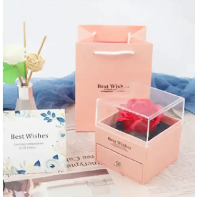 A pink rose preserved in a clear acrylic box with a matching drawer.