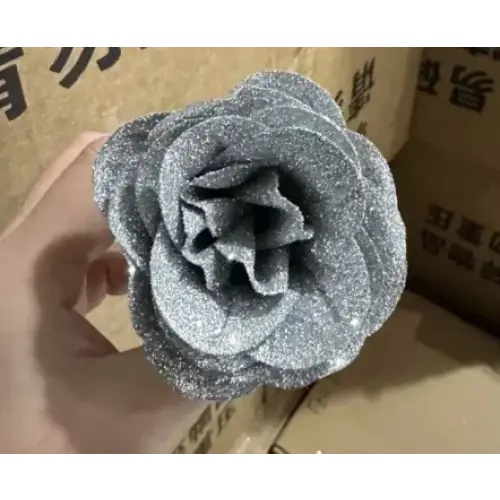 A glittery silver foam rose held in a hand.