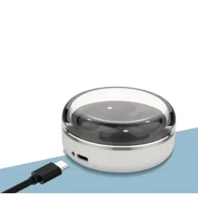 Silver circular wireless charging pad with a transparent dome cover and black usb-c cable.