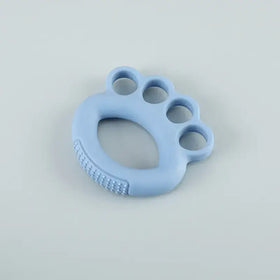 Light blue silicone baby teether shaped like a paw print with textured ridges on the underside.
