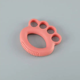 Pink silicone baby teether shaped like a paw with textured ridges for soothing gums.