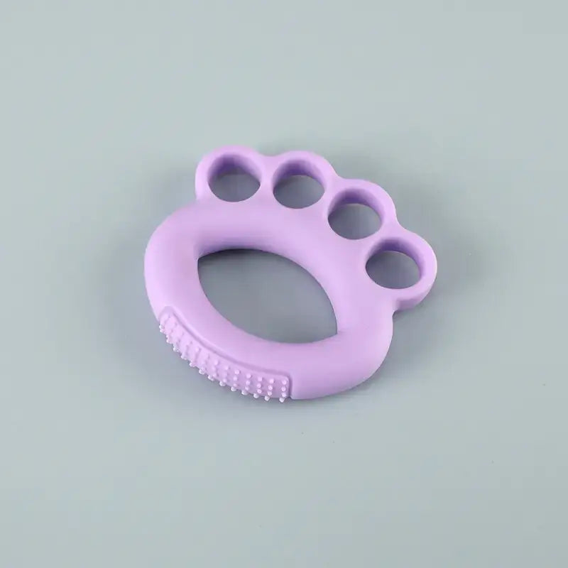 Purple silicone baby teether shaped like a paw with textured ridges along the bottom edge.