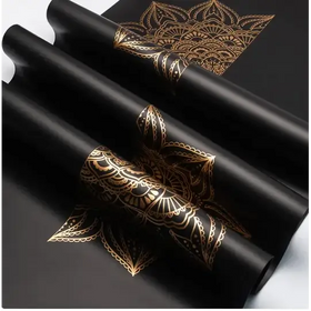 Black rolls of paper featuring intricate gold mandala designs.