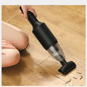 Black handheld vacuum cleaner with a transparent dust collection chamber and ergonomic grip.
