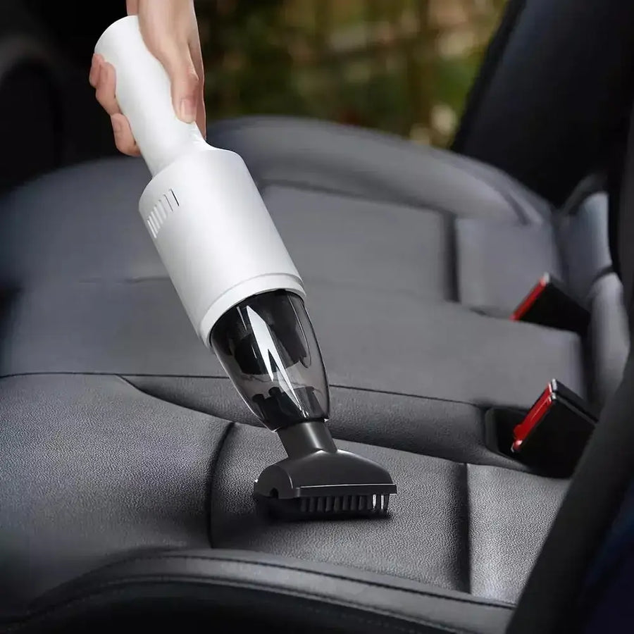 White and black handheld car vacuum cleaner with a transparent dust collection chamber.