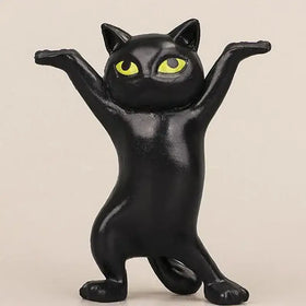 Black cat figurine with striking yellow eyes, crafted from glossy plastic.