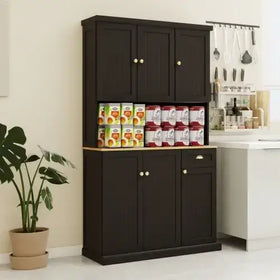 Dark brown wooden kitchen cabinet with a light wood countertop and gold-toned round knobs.