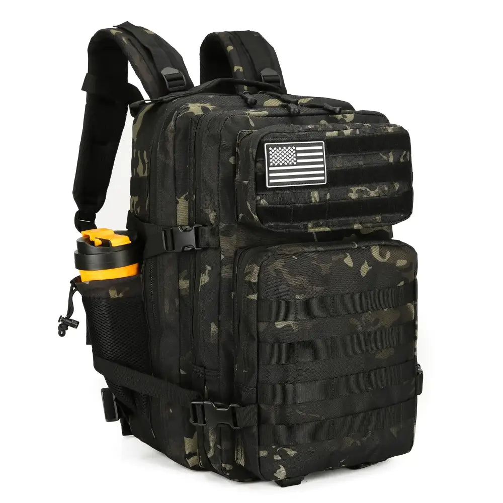 Black and olive green camouflage tactical backpack with a white american flag patch on the front pocket.