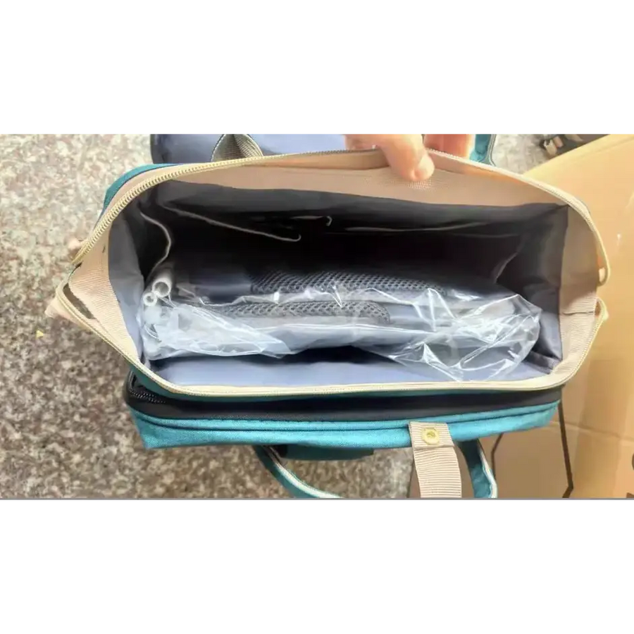 Teal and beige diaper bag with a zippered opening revealing an organized interior.