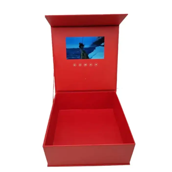 Red rectangular box with a built-in screen displaying an image of a person on water, featuring circular control buttons below the display.