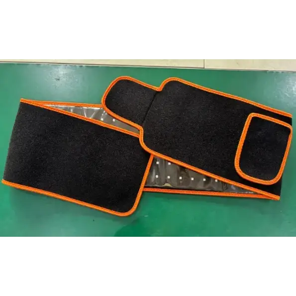 Black and orange heated waist support belt with a reflective interior lining.