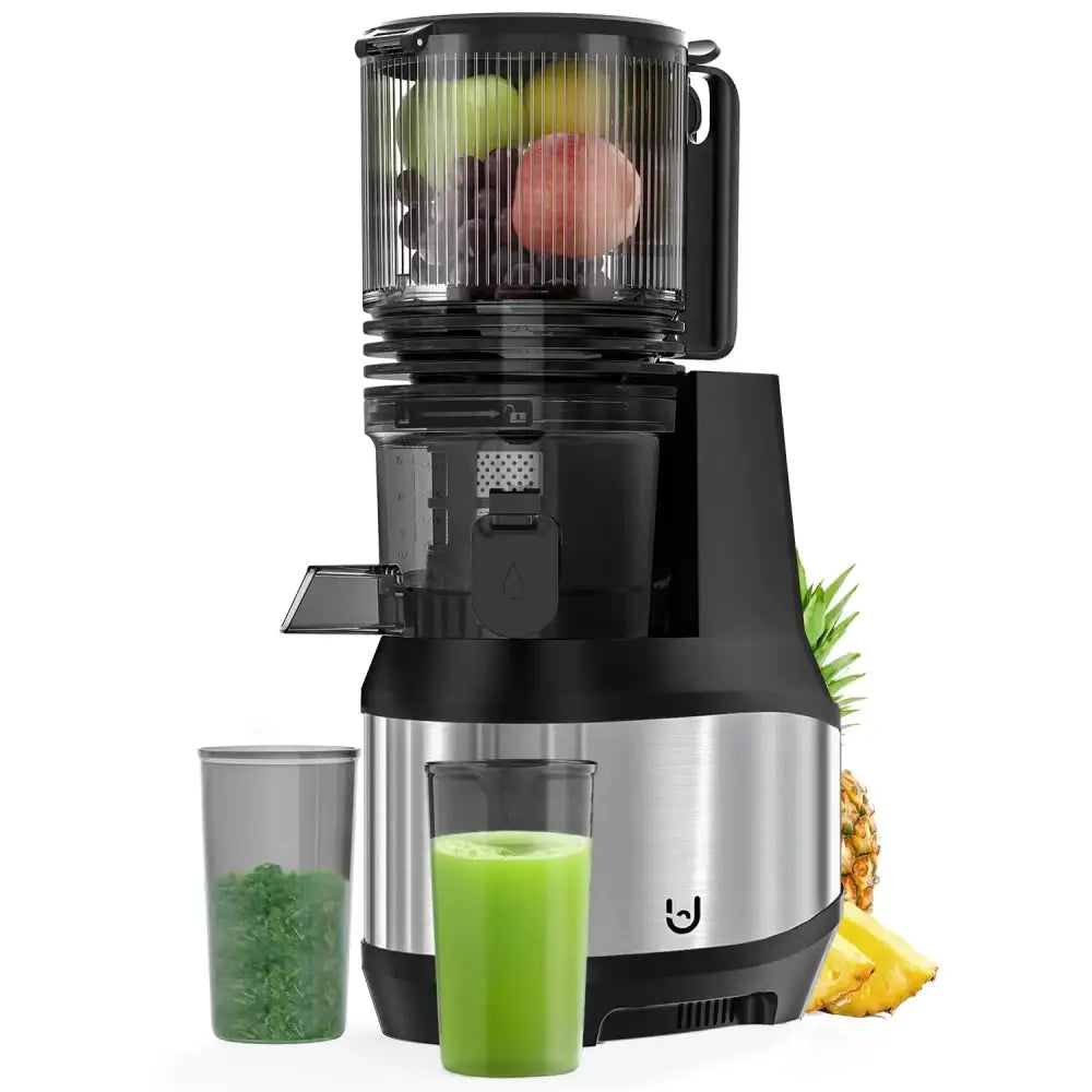 Black and stainless steel cold-press juicer with transparent feed chamber filled with fruits, accompanied by a glass of green juice and a container of pulp.