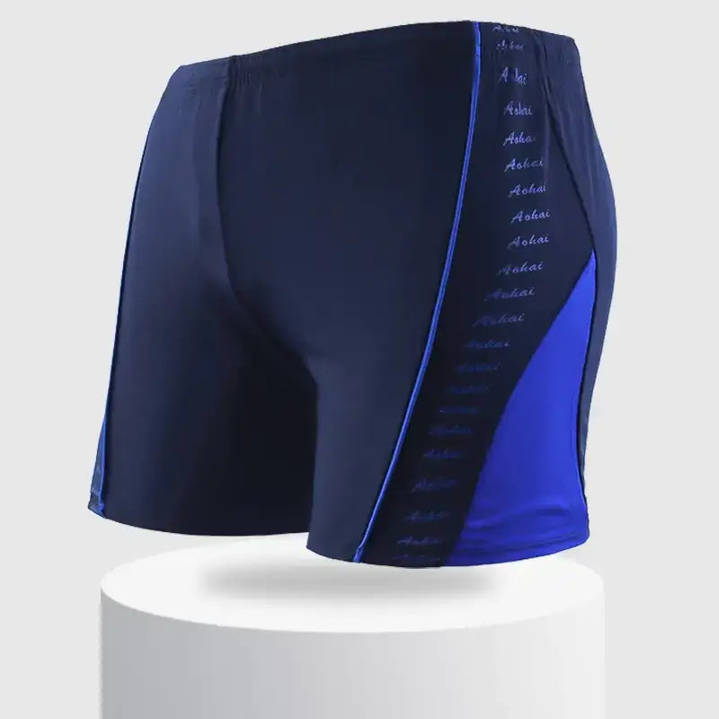 Navy blue swim trunks with a vibrant royal blue side panel and subtle white text detailing along the seam.