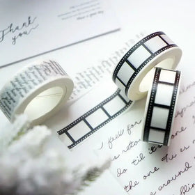 Black and white filmstrip-patterned washi tape rolls.