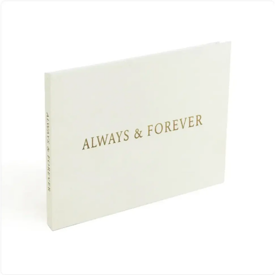 A minimalist white photo album with elegant gold foil lettering that reads ’always & forever’ on the cover.