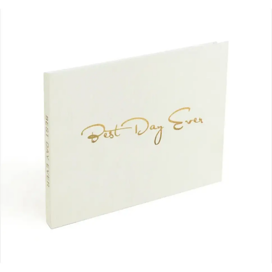 A white hardcover journal with gold foil lettering that reads ’best day ever.’