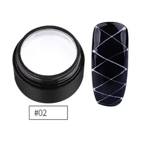 Black cylindrical container with white gel inside, next to a black nail tip decorated with silver crisscross lines.