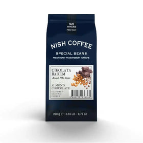 A dark blue bag of nish coffee’s almond chocolate flavored ground coffee, featuring a white label with images of almonds and chocolate pieces.