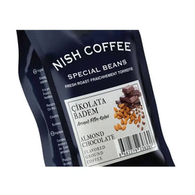 Nish coffee special beans almond chocolate flavored ground coffee in a dark blue resealable pouch with white label and imagery of almonds and chocolate pieces.