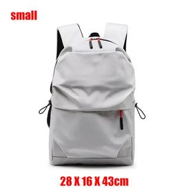A sleek, small gray backpack with black straps and red zipper pulls.