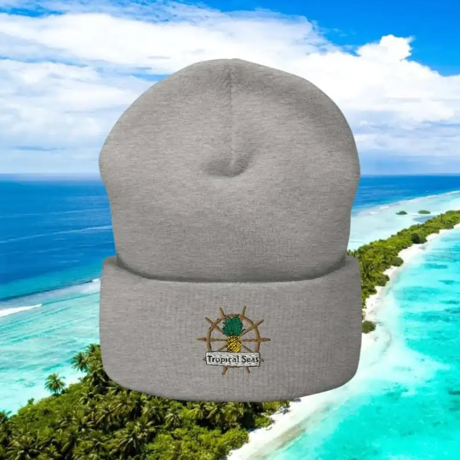 Gray knit beanie with a pineapple and ship wheel embroidered on the cuff.