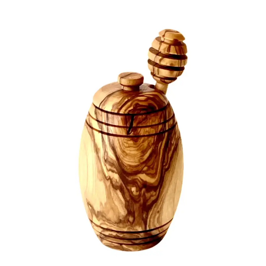 Handcrafted olive wood honey jar with a natural, swirling grain pattern and a matching wooden dipper.
