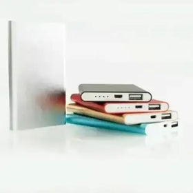 A sleek, rectangular silver power bank with a matte finish and visible usb ports.