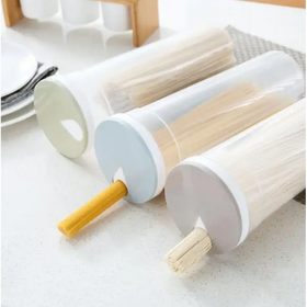 Three transparent cylindrical pasta storage containers with pastel-colored lids, each holding different types of noodles.