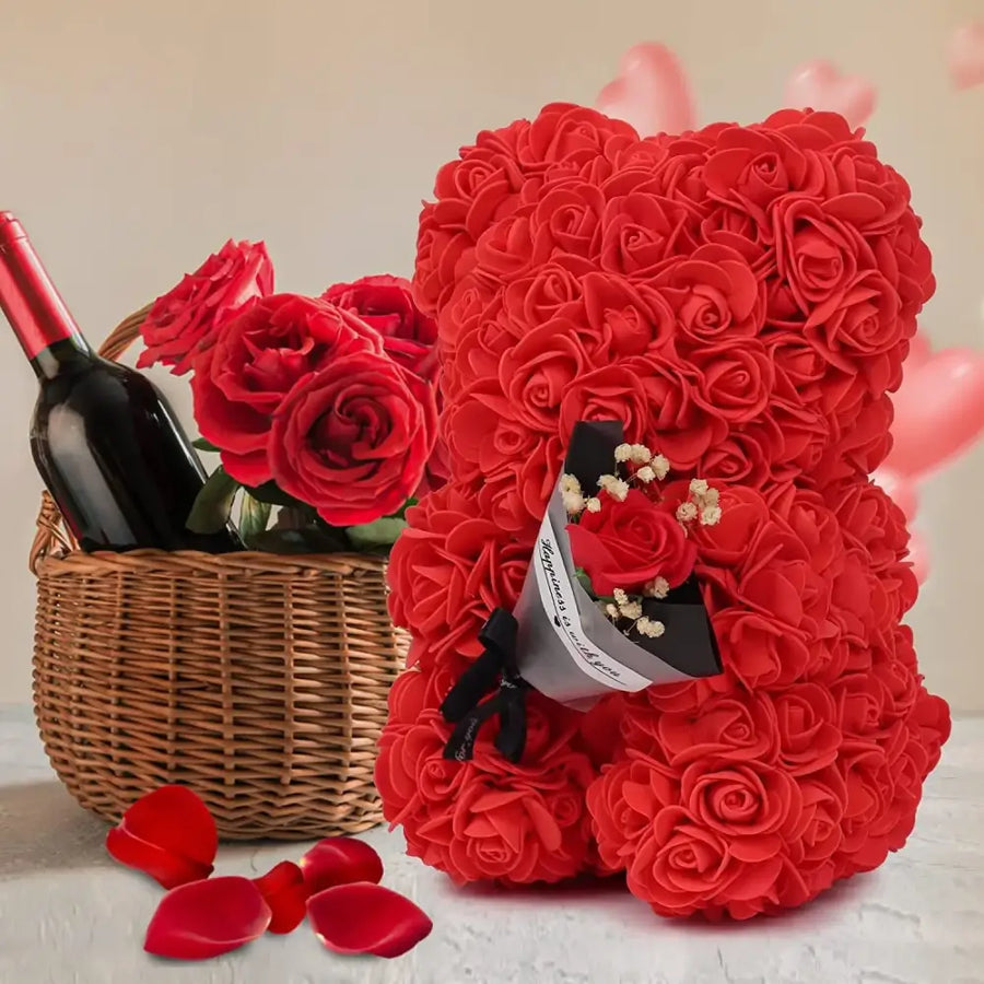 A plush red rose-covered teddy bear with a small bouquet of flowers tucked into its chest.