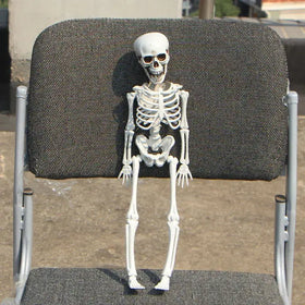 White plastic skeleton figurine with detailed bone structure and dark sunglasses.