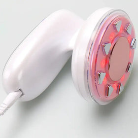 White handheld facial treatment device with a circular red led light panel and metallic accents.