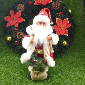 Red and white plush santa claus figurine with a gold-trimmed hat, fluffy beard, and sack of pine needles.